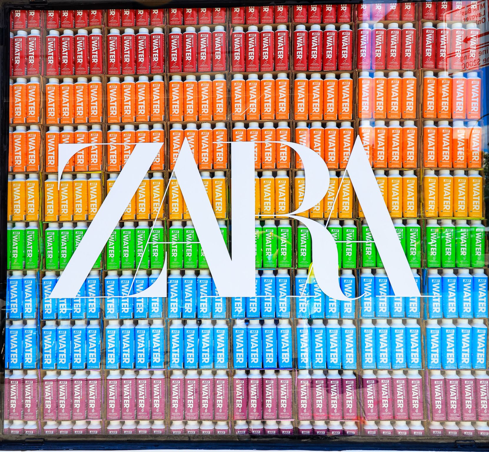 Colorful lighters in rainbow rows with a clear window showing the white ZARA logo at the center.