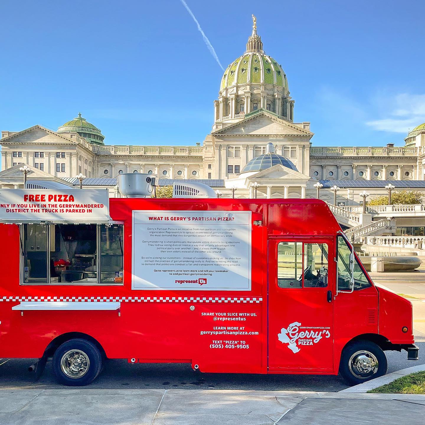 Gerry’s Pizza food truck with menu and free pizza sign parked by a green-domed government building.