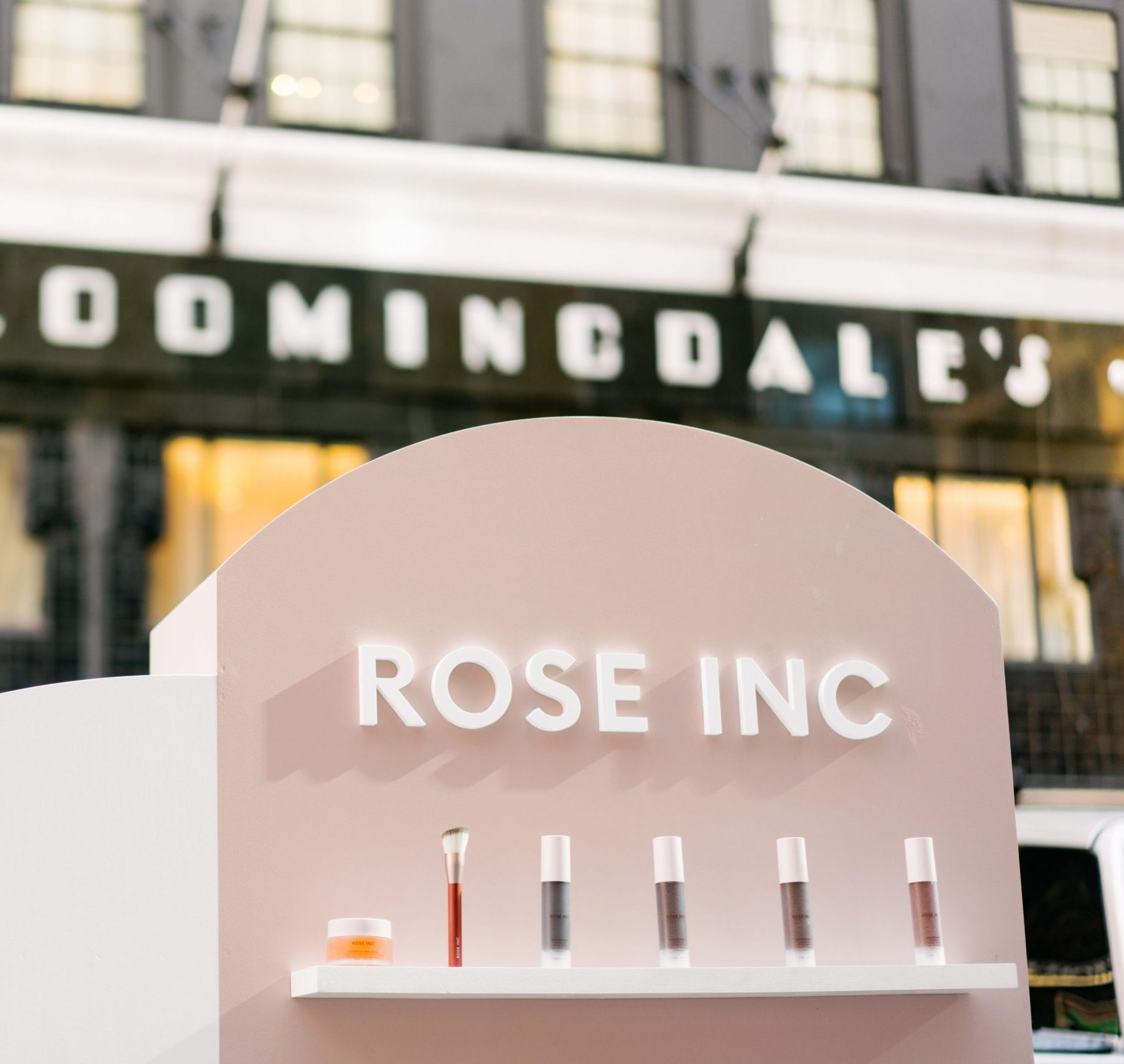 ROSE INC mobile pop up with beauty products and a brush in front of Bloomingdale's storefront.