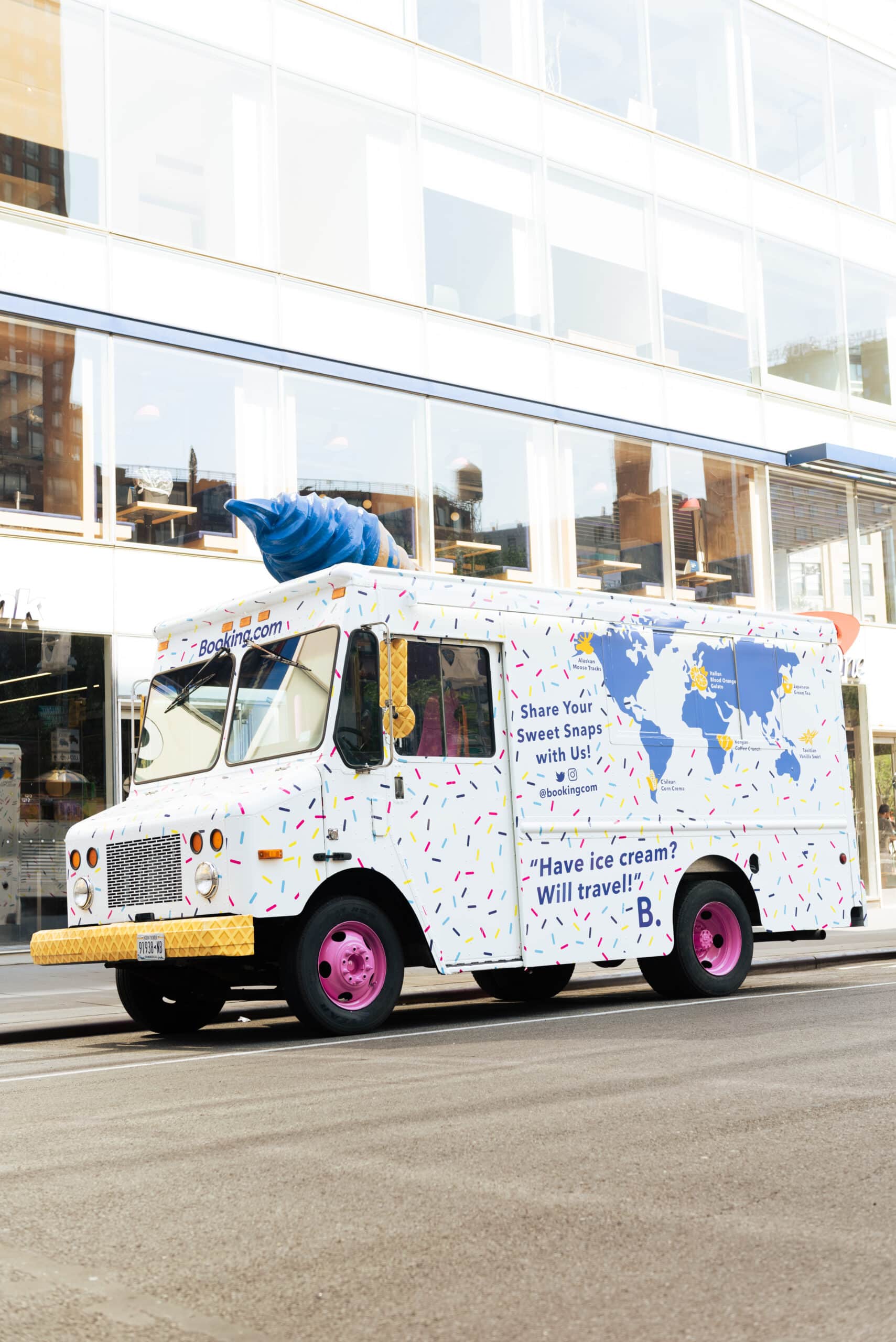 White food truck with sprinkles, pink wheels, blue ice cream cone on top, and world map graphic.