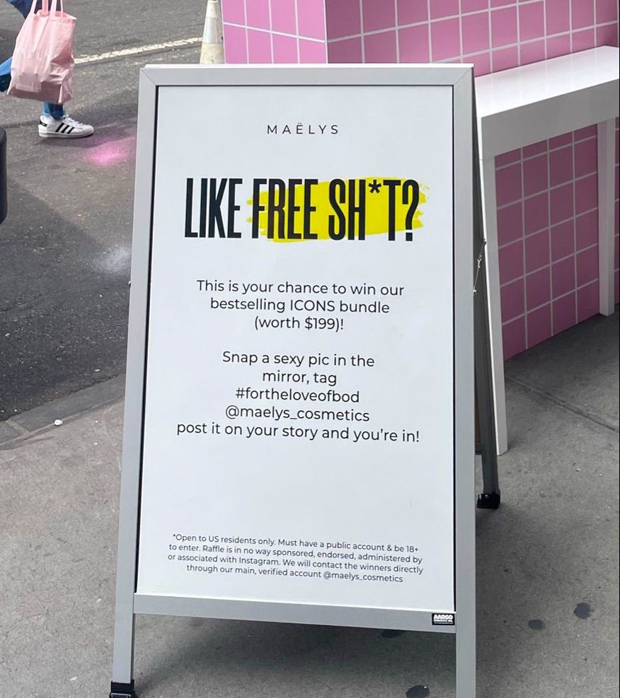 Sandwich board outside advertises Maëlys Cosmetics pop-up and a prize for sharing a selfie online.