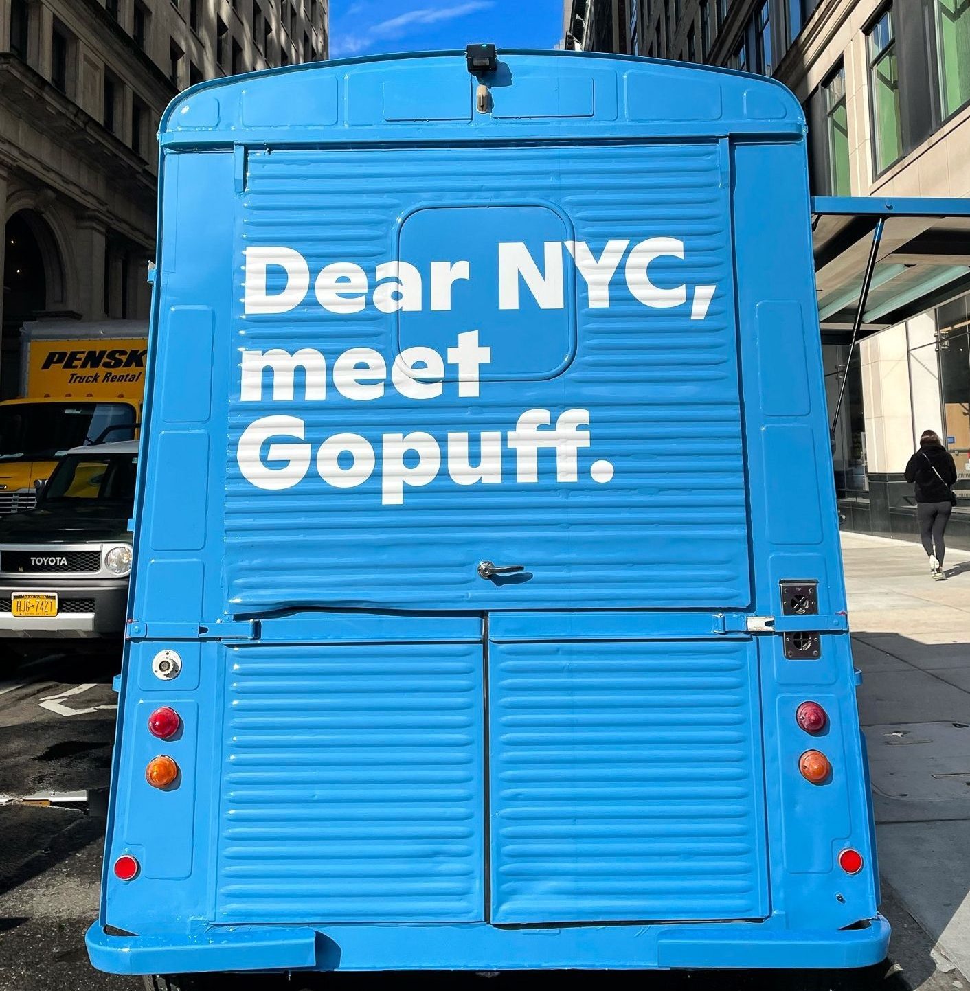 Blue delivery truck parked on city street with large white text: Dear NYC, meet Gopuff.