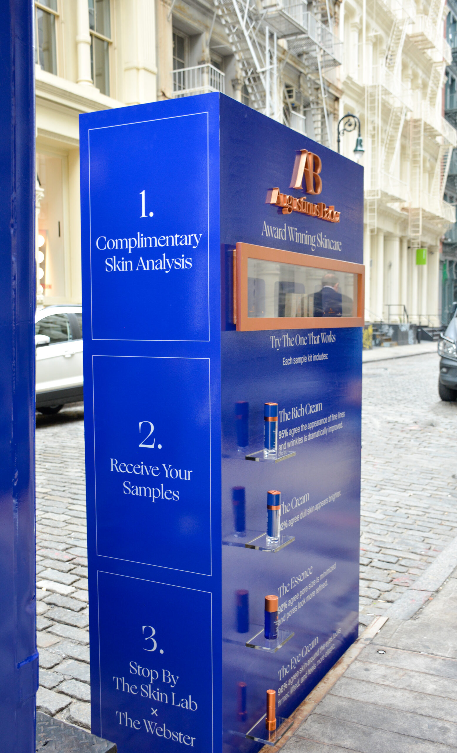 Blue skincare kiosk on cobblestone street with free skin analysis, samples, and product info.