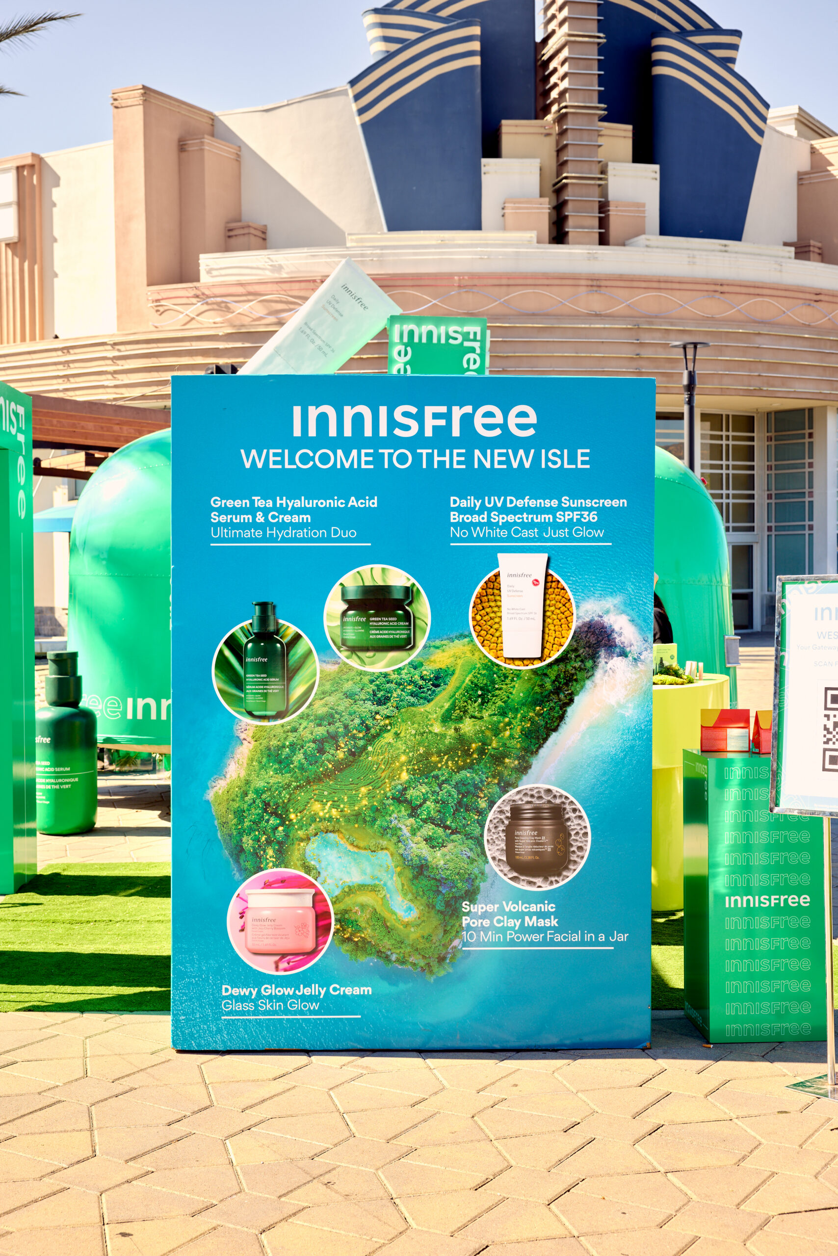 Innisfree outdoor sign with product info and images on a green island, promoting mobile tour.