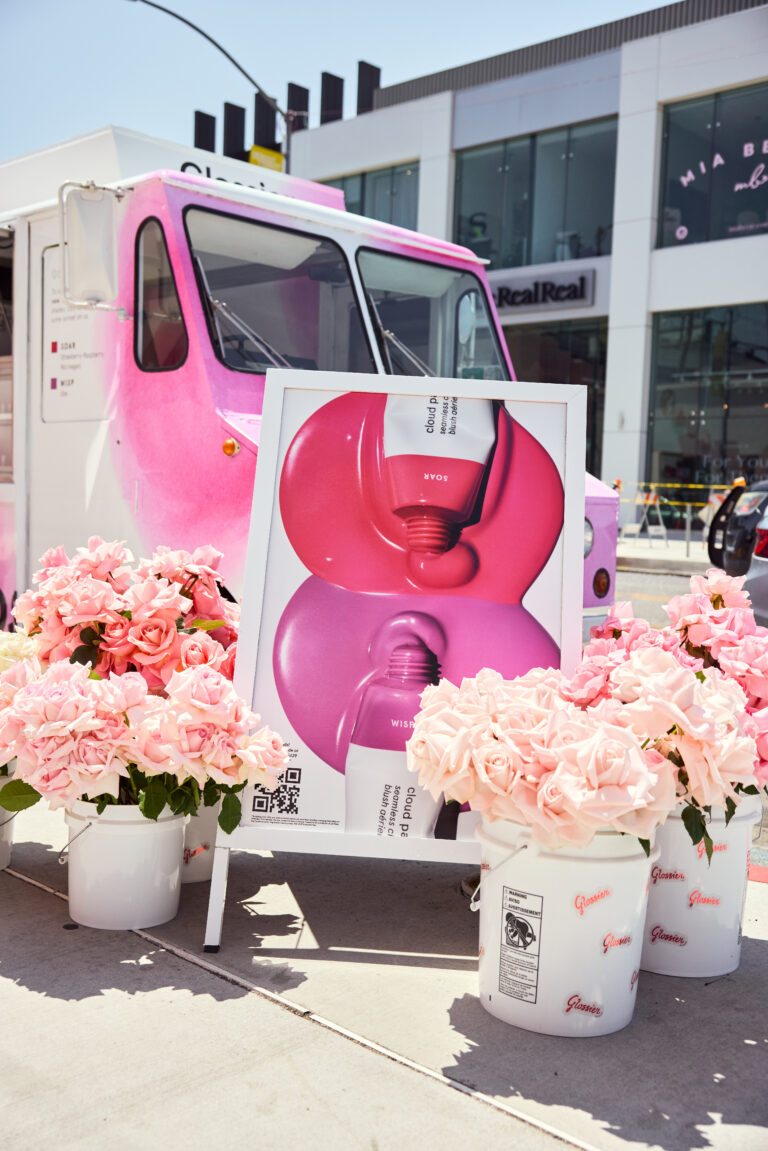 Pink and white ice cream truck with pink roses and a poster of nail polish, Glamsquad, OPI logos.