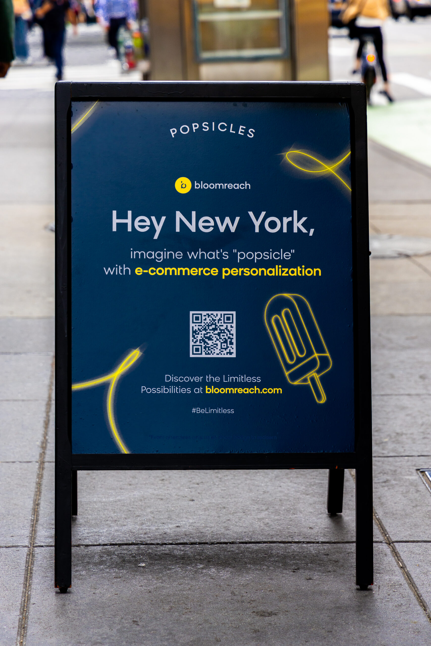 Sidewalk sign for Bloomreach e-commerce features popsicle graphic, QR code, and web link.