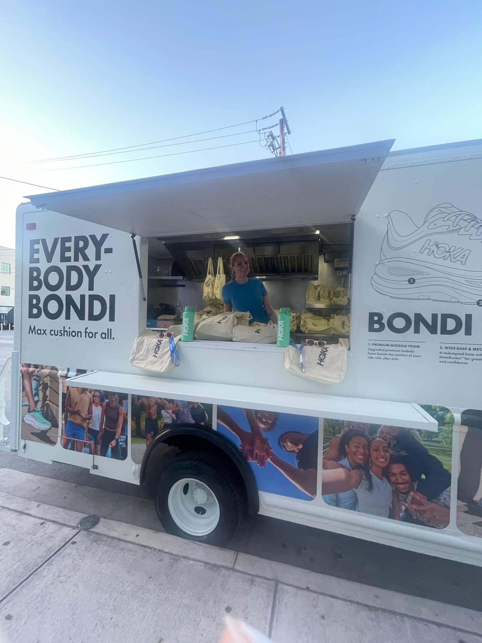 Person in EVERYBODY BONDI food truck with shoes, tote bags, and shoe graphics on the exterior.