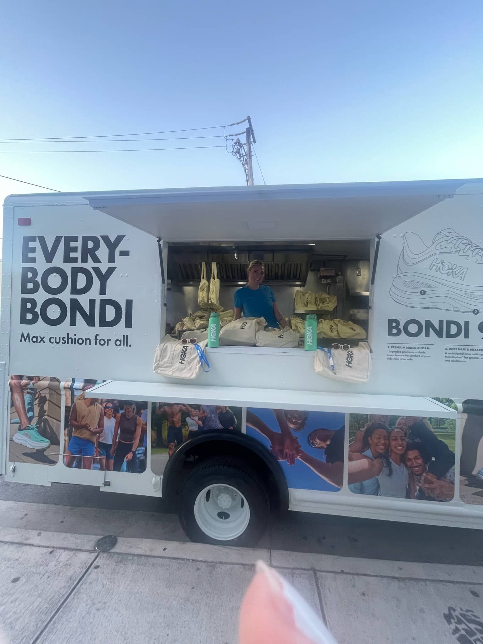 HOKA Bondi shoe truck with “EVERYBODY BONDI” slogan, people’s faces, and shoe boxes on counter.