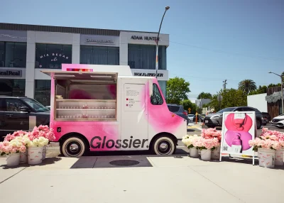 A pink food truck parked on the side of a road.