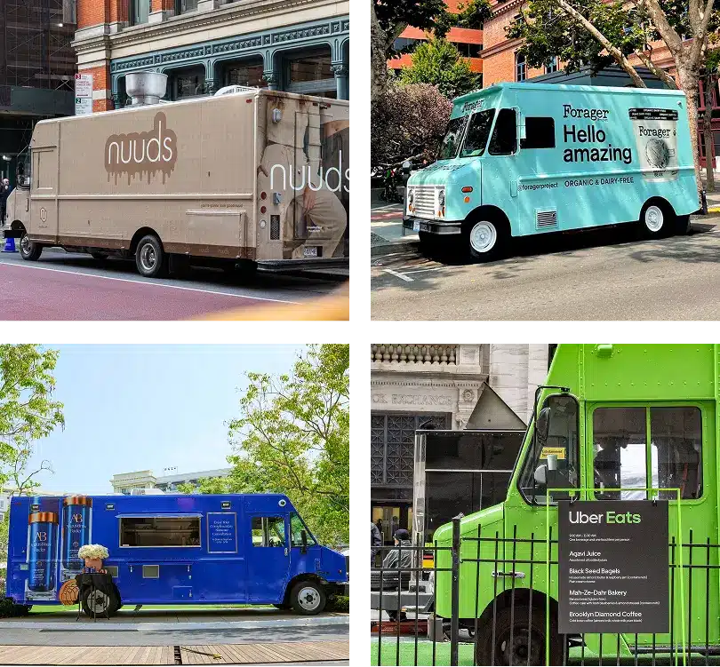 Four food trucks in different colors—beige, light blue, blue, and green—are parked on city streets, each displaying unique branding and signage. A few trees and buildings are visible in the background.