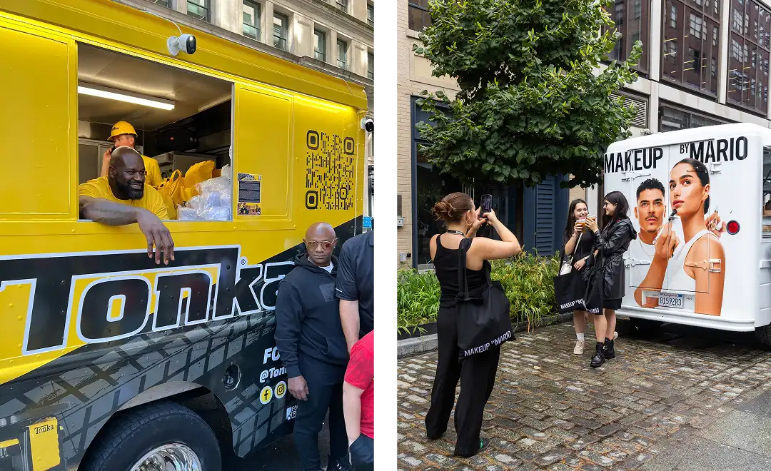 On the left, men in yellow shirts work inside a bright yellow Tonka food truck. On the right, people take photos of a white Makeup by Mario truck featuring large images of a man and woman, parked on a cobblestone street.