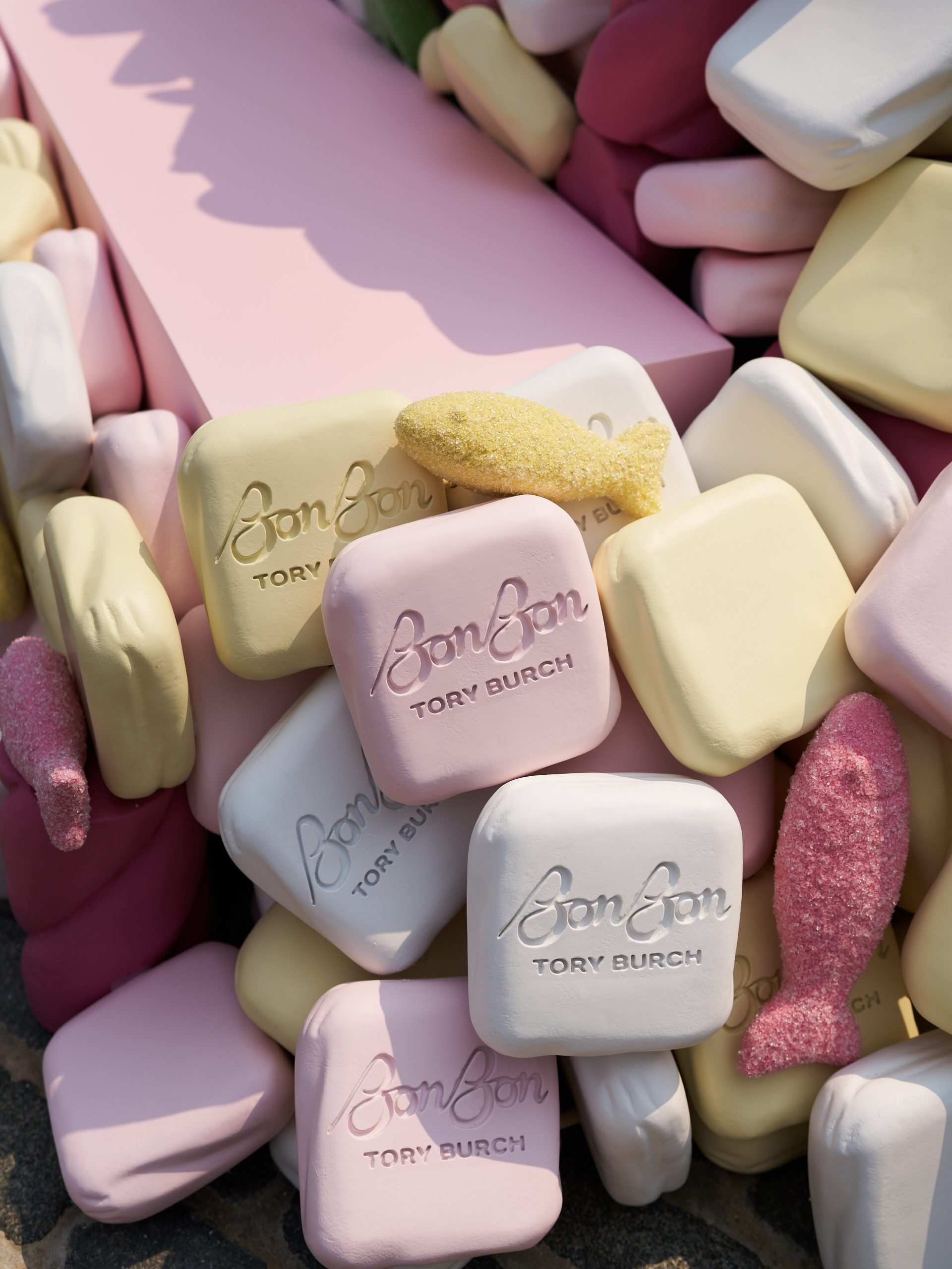 Pastel pink, yellow, and white soap bars embossed “BonBon TORY BURCH”; some are fish-shaped.