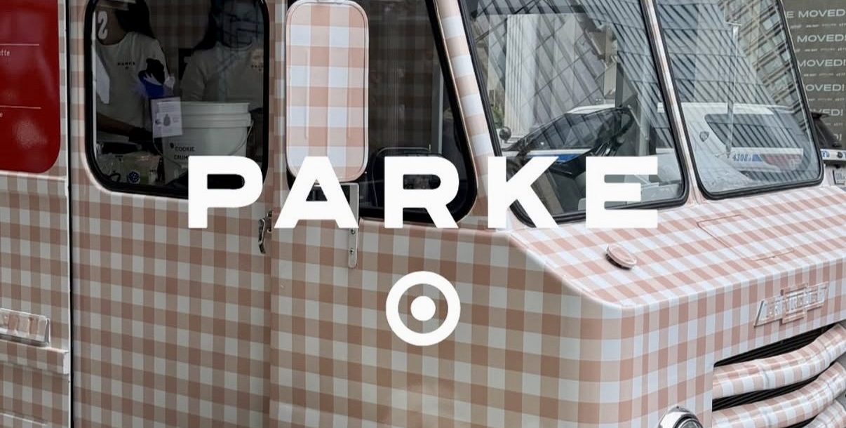 Pink and white gingham food truck parked on city street with white flowers, "PARKE" and Target logo.